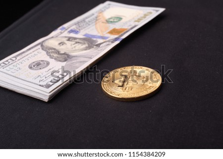 Golden metal bitcoin on dollar bills background. a lot of money in cash. 100 dollars texture. dear bitcoin. Gold coin. Profit from mining. Earnings on the growth of cryptocurrencies