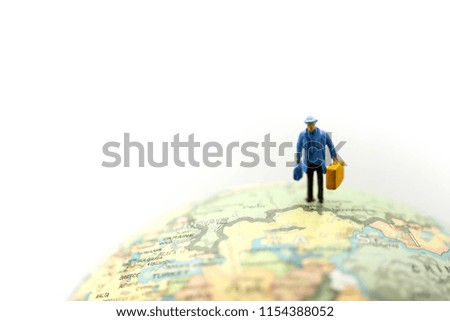Miniature people : travelers with backpack standing on world map, walking to destination