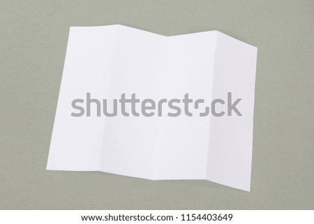 Four- fold white template paper on grey background.
