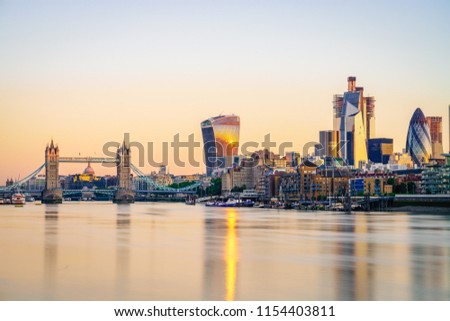 Tower Bridge and the bank district of central London with famous skyscrapers and other landmarks at sunrise