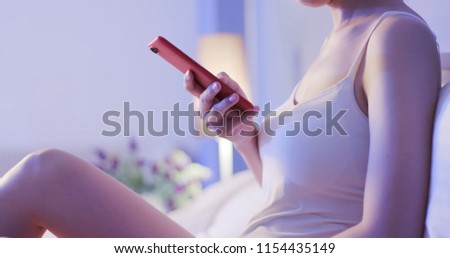 woman use phone on bed at night