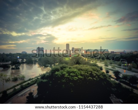 Blurry background aerial midtown and uptown Houston flood with high water along Buffalo Bayou River at sunset. Heavy rains from hurricane disaster caused many flooded areas in greater Houston area