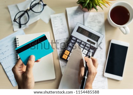 Stressed young woman calculating monthly home expenses, taxes, bank account balance and credit card bills payment, Income is not enough for expenses. Royalty-Free Stock Photo #1154485588