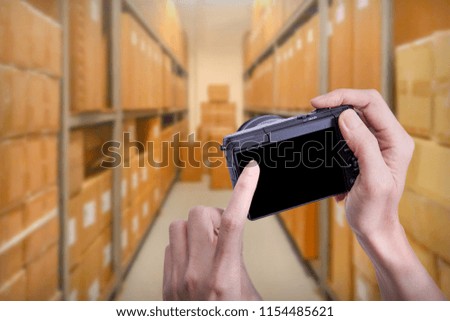 Woman hand using mock up Mirrorless camera in hand at warehouse background, with copy space