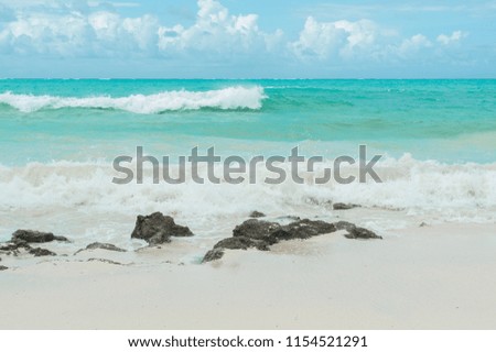 Turquoise waves of the Indian ocean run on the white beach of the island of Zanzibar.