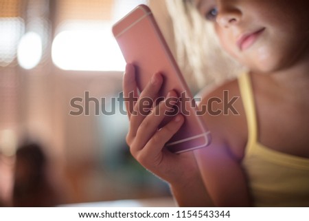 Little girl using cell phone. Copy space. Close up. Focus is on hands.
