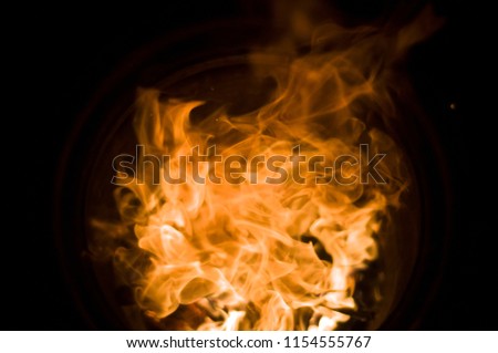 Fireball. Tongues of a flame of fire of orange-yellow color from burning firewood. Fire in a barrel.
