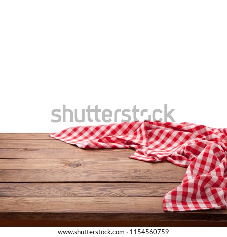Red checkered tablecloth on empty wooden table. Napkin close up top view mock up for design. Kitchen rustic background.