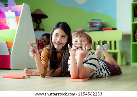 young woman teacher join and exciting with preschool kids boys watching TV Video movie  documentary content movie together, closely warning and suggestion recommendation of teacher to kids concept