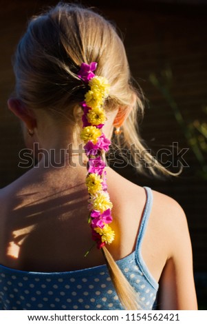A girl from the back side with tail decorated with summer flowers. concept