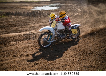 A picture of a biker doing a trick, and jumping into the air.
Motocross Championship. sports fast driving. bike large small.