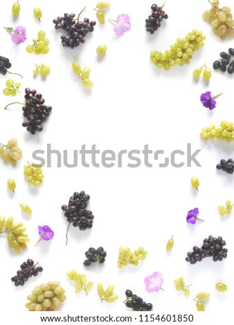 A frame made of black and green grapes isolated on a white background. The pattern of grapes of different varieties, top view, flat lay. Food background.