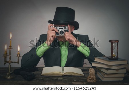 Secret service spy agent take a picture with photo film camera in his hands. Detective or spy agent or police inspector concept.
