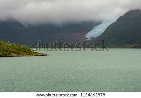 Second largest glacier in Norway ”Svartisen” with fjord water in foreground and fog in background, picture from Northern Norway.