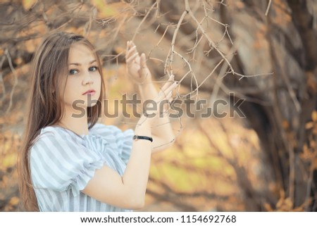 Young girl on a walk in the autumn park
