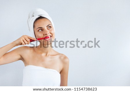 Smiling happy young woman with healthy teeth holding a tooth brush white background. Clean beauty and healthy concept