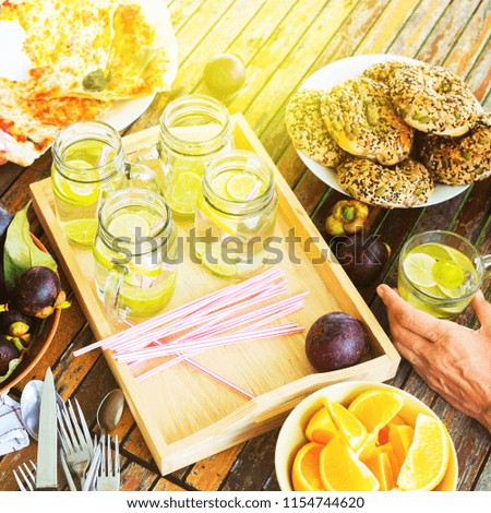 Pizza snack tropical fruits mangosteen orange healthy donuts summer cool drink with a lime on wooden table. Top view. Open air picnic