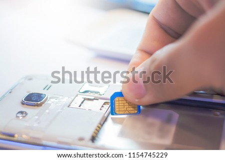 Employees are putting nano SIM cards in the store for customers to buy,Men's hands, changing the SIM card. Time to travel Royalty-Free Stock Photo #1154745229