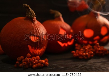 Halloween pumpkin Jack-o-lanterns on the dark wooden background