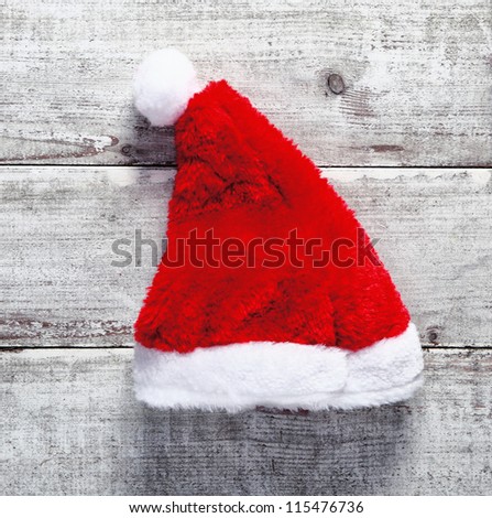 Red Santa Claus hat lying on rustic weathered wooden boards for a country Christmas greeting