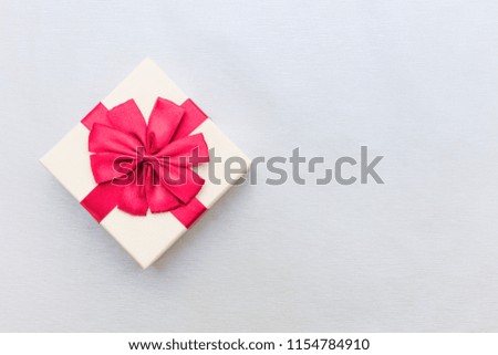 gift box with gift or voucher card top view on wooden background. parcel with red wrap ribbon for commerce shopping on winter holidays christmas new year concept.