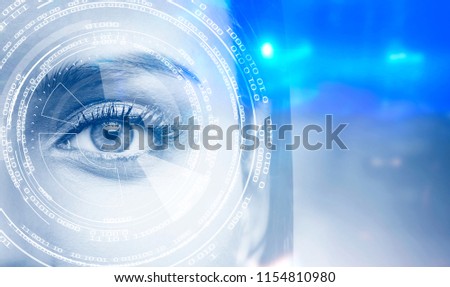 Glowing HUD interface against a gray eye of a young and pretty woman. Blurred blue background. Concept of hi tech. Toned image double exposure mock up