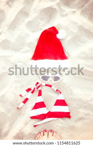Christmas Concept, Summer holiday background, Beach accessories flat lay: Santa hat, swimming glasses and bikini