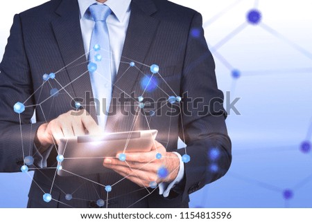 Unrecognizable young businessman with a tablet computer. Double exposure of a network hologram. Blue background. Toned image mock up