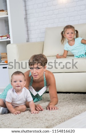 mom with two children playing at home in the room, children one year and four years of age