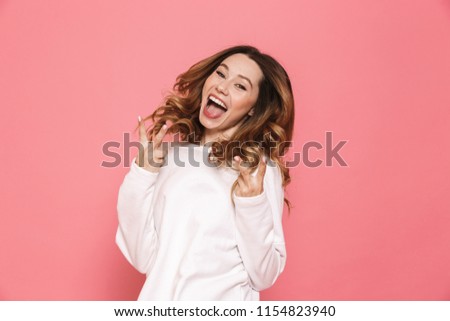 Portrait of a happy young casual girl screaming isolated over pink background, showing peace