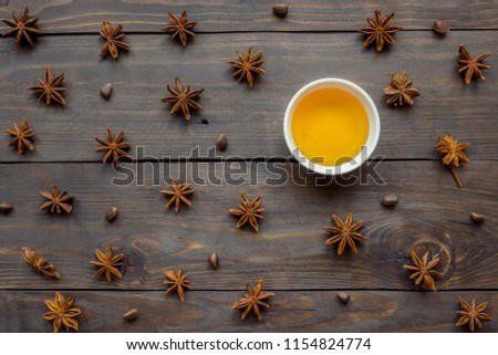 Liquid honey in a plate and star anise on a Dark wooden background. the concept of the starry night sky.