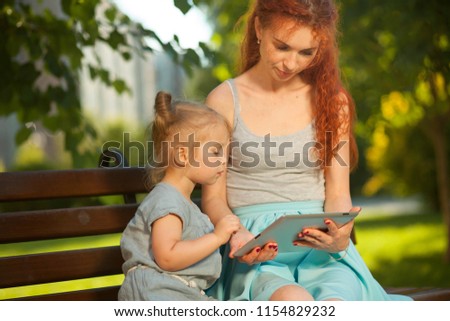 Mom teaches the child to use the tablet