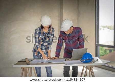 woman civil architect engineer discussion of building with building plan,engineering and architecture concept.Blue print is fake only for stock photo.