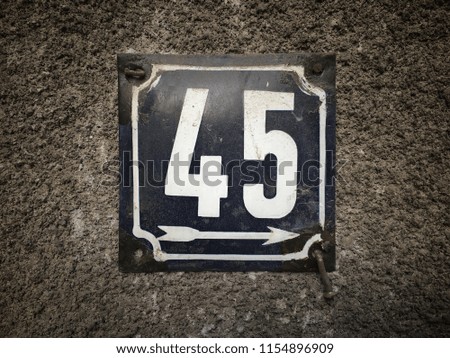 Vintage grunge square metal rusty plate of number of street address with number closeup