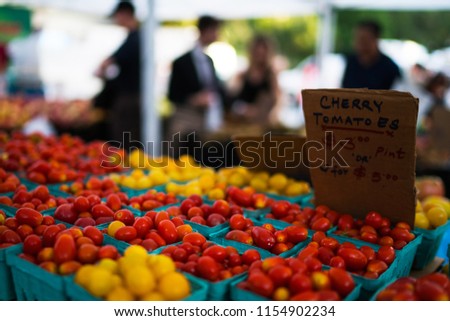 In paper containers packed tomatoes cherry ready for sale in a vegetable farmer's market. Tomatoe grapes on display at the market. Eco product. Ecology and preservation of the environment concept.