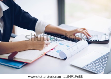 Business woman working with financial data hand using calculator and writing make note with calculate. Business financial and accounting concept. Royalty-Free Stock Photo #1154919688