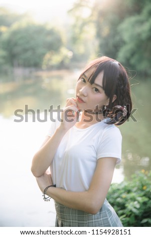 portrait of asian girl with white shirt and skirt looking in outdoor urban vintage film style