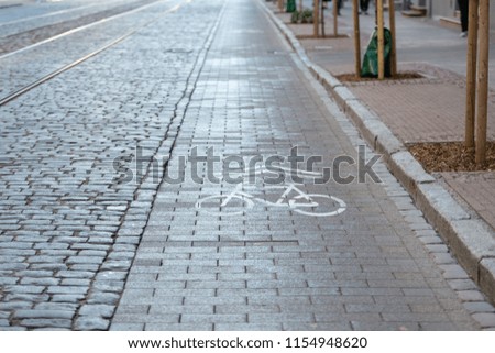 Cobbled street with tram rails and separate lanes for cyclists.