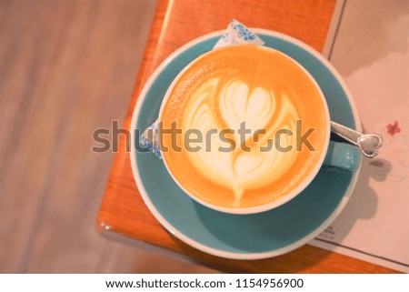 a cup of coffee on wooden table in warm light at coffee cafe