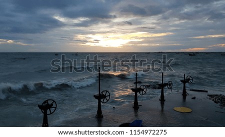 Sea waves splashing against the watergate ,twilight and orange -dark sky background