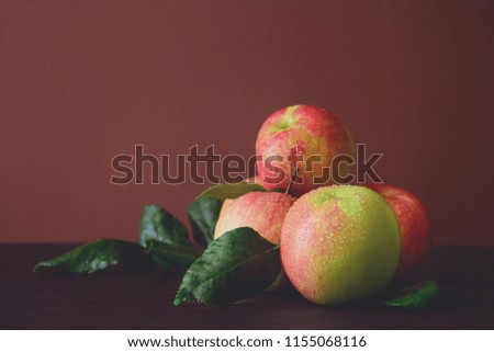 Ripe red apples on brown wooden background. Toned