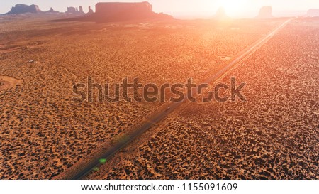 Bird's eye scenery view of unique geological formation of Arizona landmark. Monument Valley rocks one of the National symbols of the United States of America. Sandy desert landscape with highway road