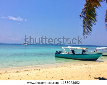 Boat anchored on the sandy shores of laughing bird caye off the coast of belize