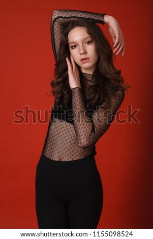 Beautiful girl posing on a red background