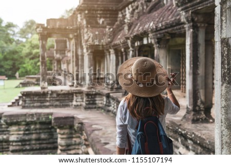 Young woman traveler visiting at Angkor Wat complex, Khmer architecture heritage in Siem Reap, Cambodia