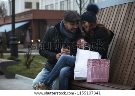 Young shopping couple drinking coffee and looking very happy