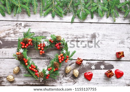 Christmas tree heart with red berries on wooden background 