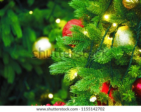 New year holiday or christmas green background. Branches of christmas trees decorated with red and golden decorations and lights, garlands and toys. Illumination. New Year and seasons greeting concept