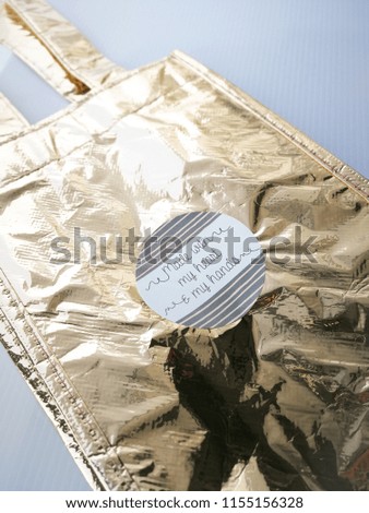 Reusable Metallic paper bag for gift with sticker words "made with my heart, my hands" isolated on white background.