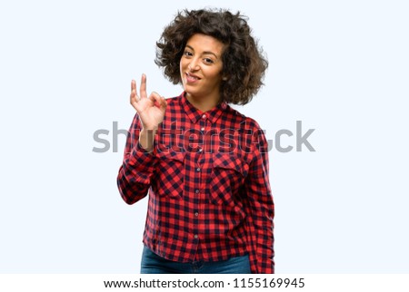 Beautiful arab woman doing ok sign with hand, approve gesture